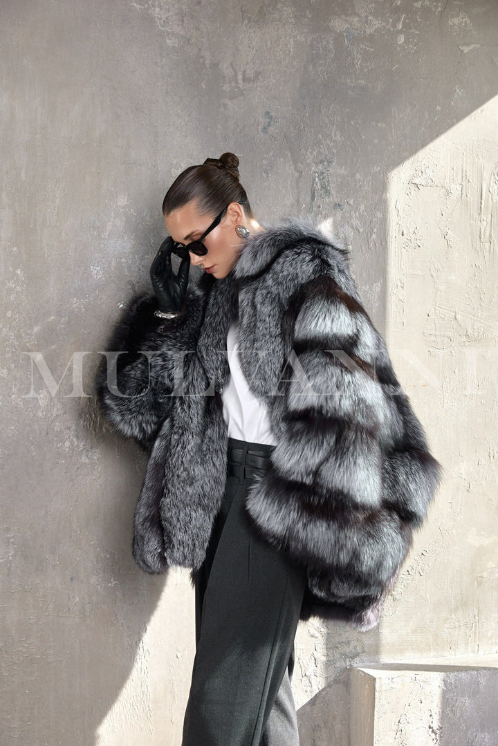 A woman showcases a refined winter look in a genuine silver fox fur coat, belted at the waist to highlight the elegant structure.