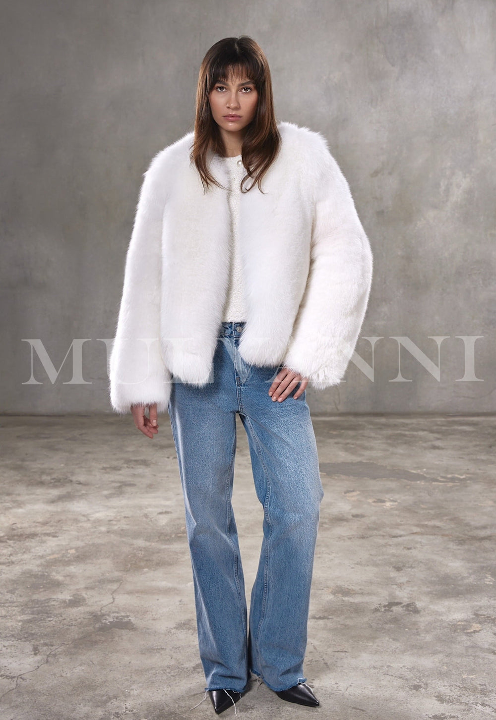Styled in a plush Arctic fox fur coat, woman exudes chic elegance with the voluminous silhouette and soft satin-lined finish.