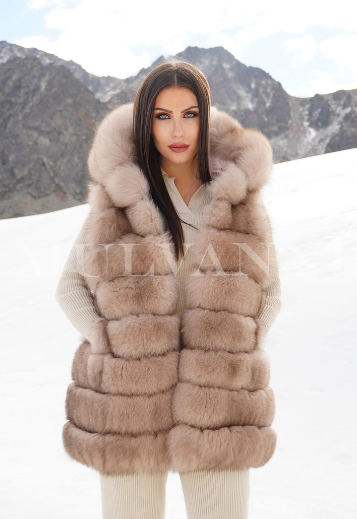 Model wearing a reversible merino wool parka and fox fur vest in snowy mountains, luxury designer coat for extreme and snow weather conditions.