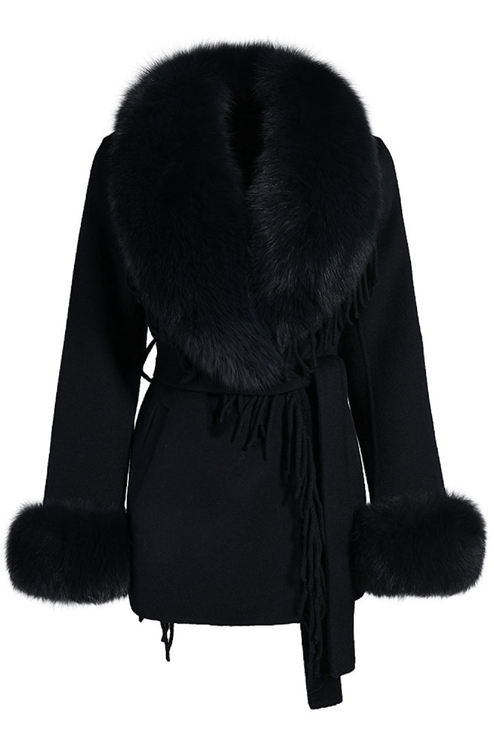 Short black cashmere coat with voluminous fox fur collar, combining luxury materials and timeless design.