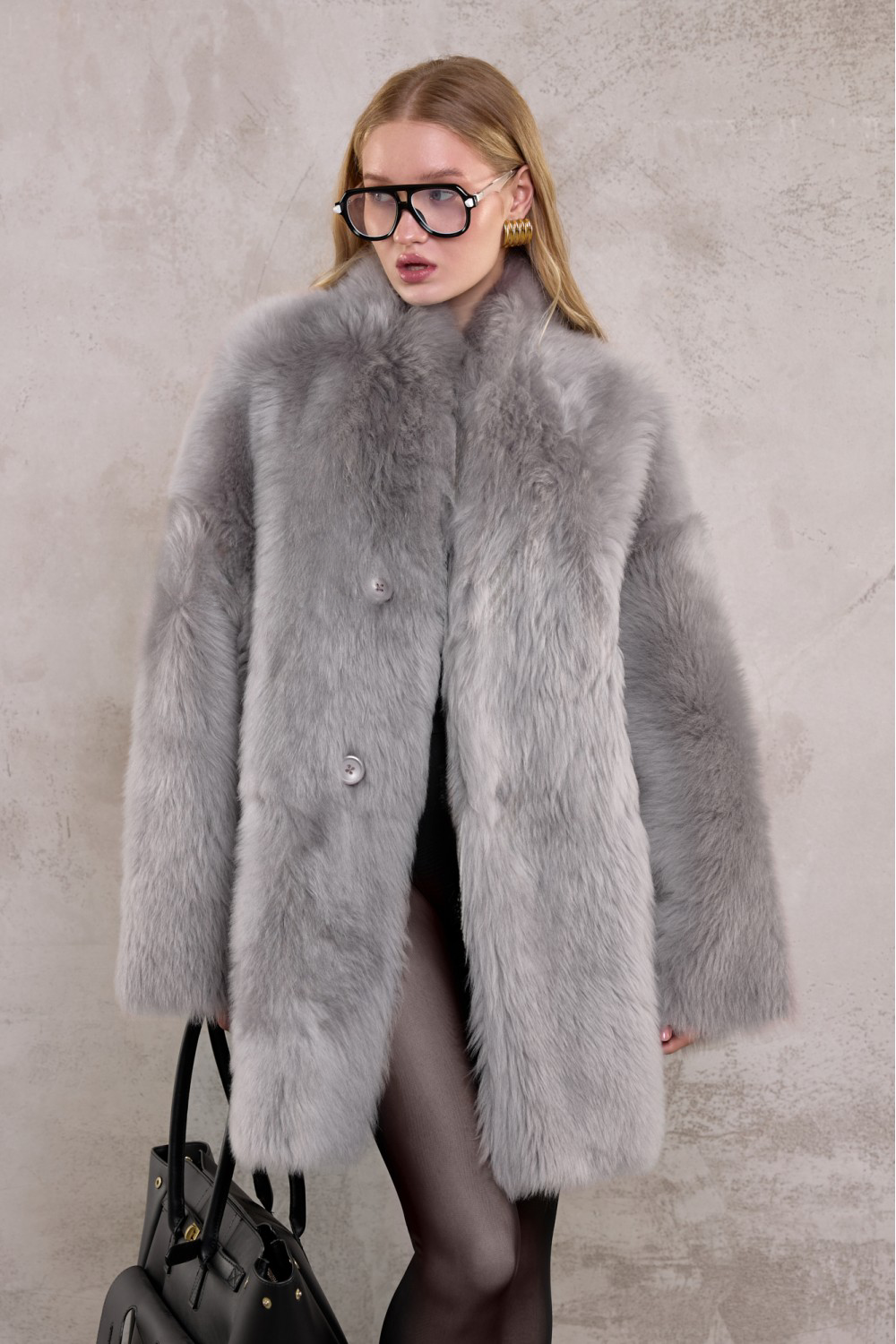 Luxurious genuine shearling coat in light grey, styled for refined cold-weather fashion.