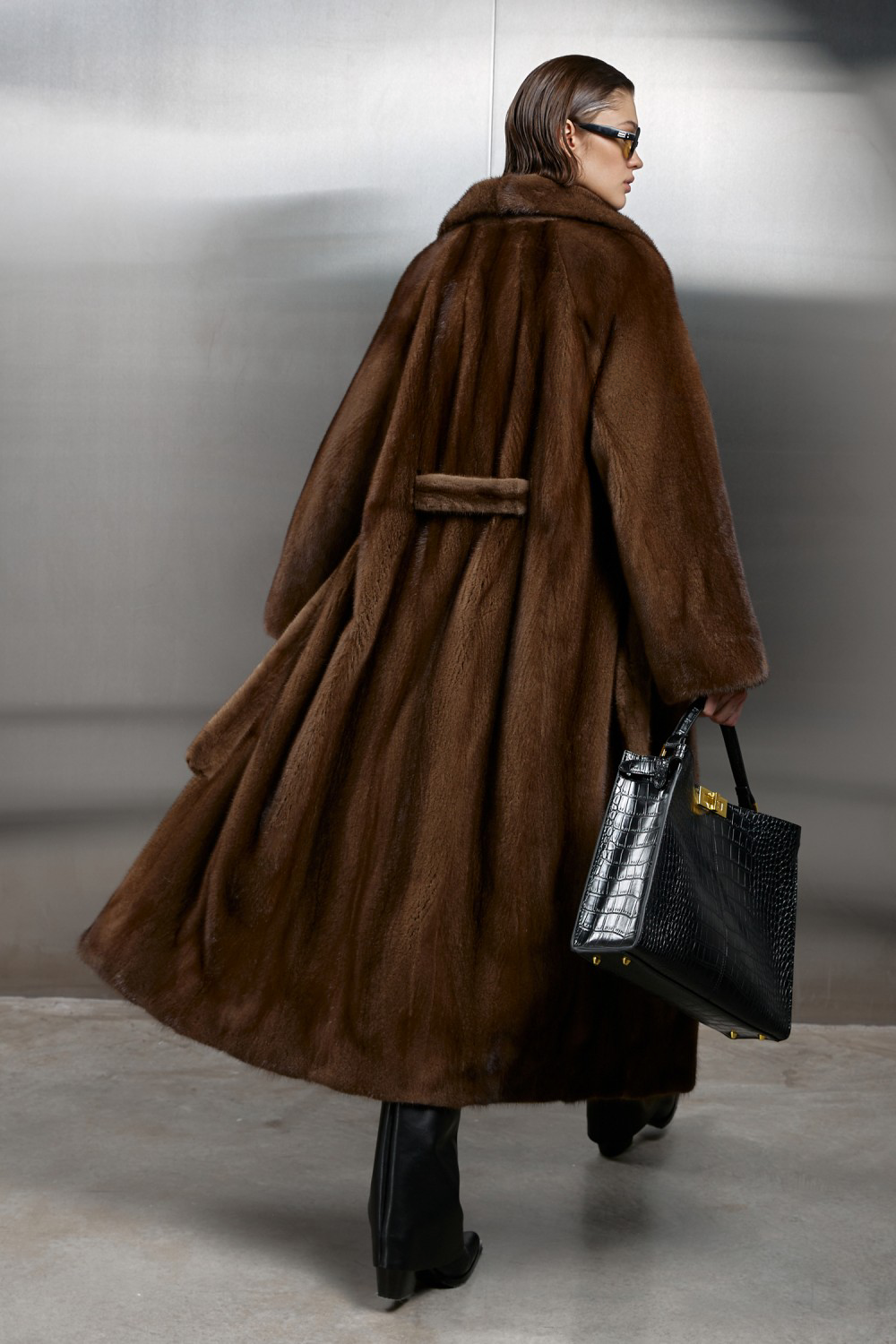 Luxurious long genuine brown mink fur coat with satin lining, showcasing elegance and warmth in fashion.