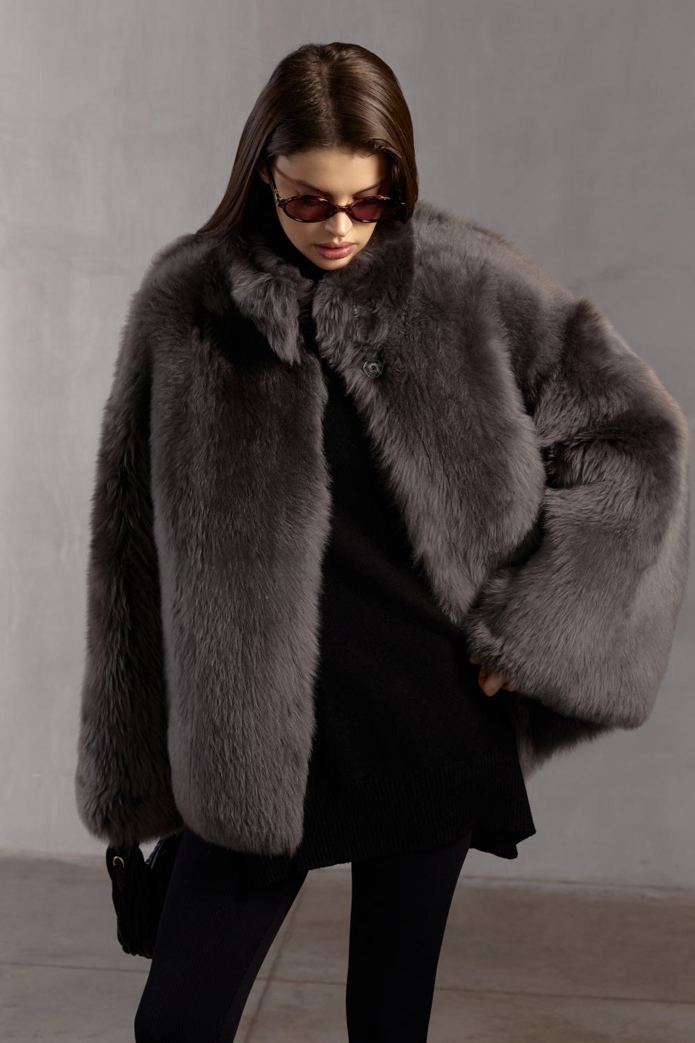 Luxurious genuine shearling coat in grey, styled for refined cold-weather fashion.