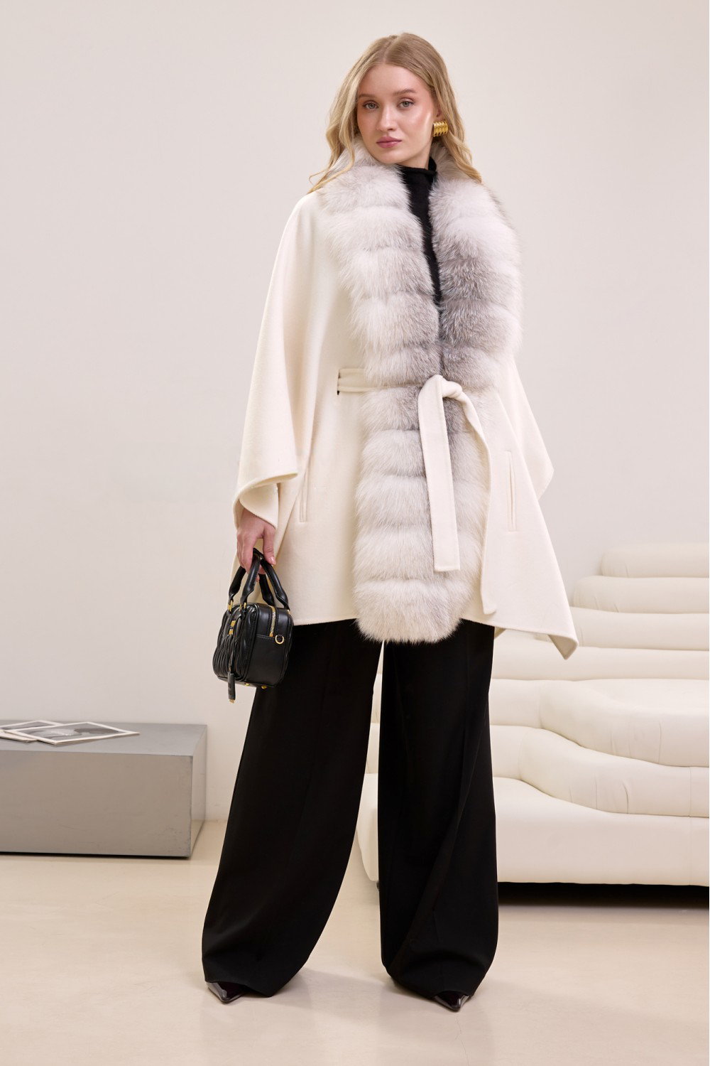 Chic off-white cape in premium cashmere and fox fur, styled for refined cold-weather elegance.