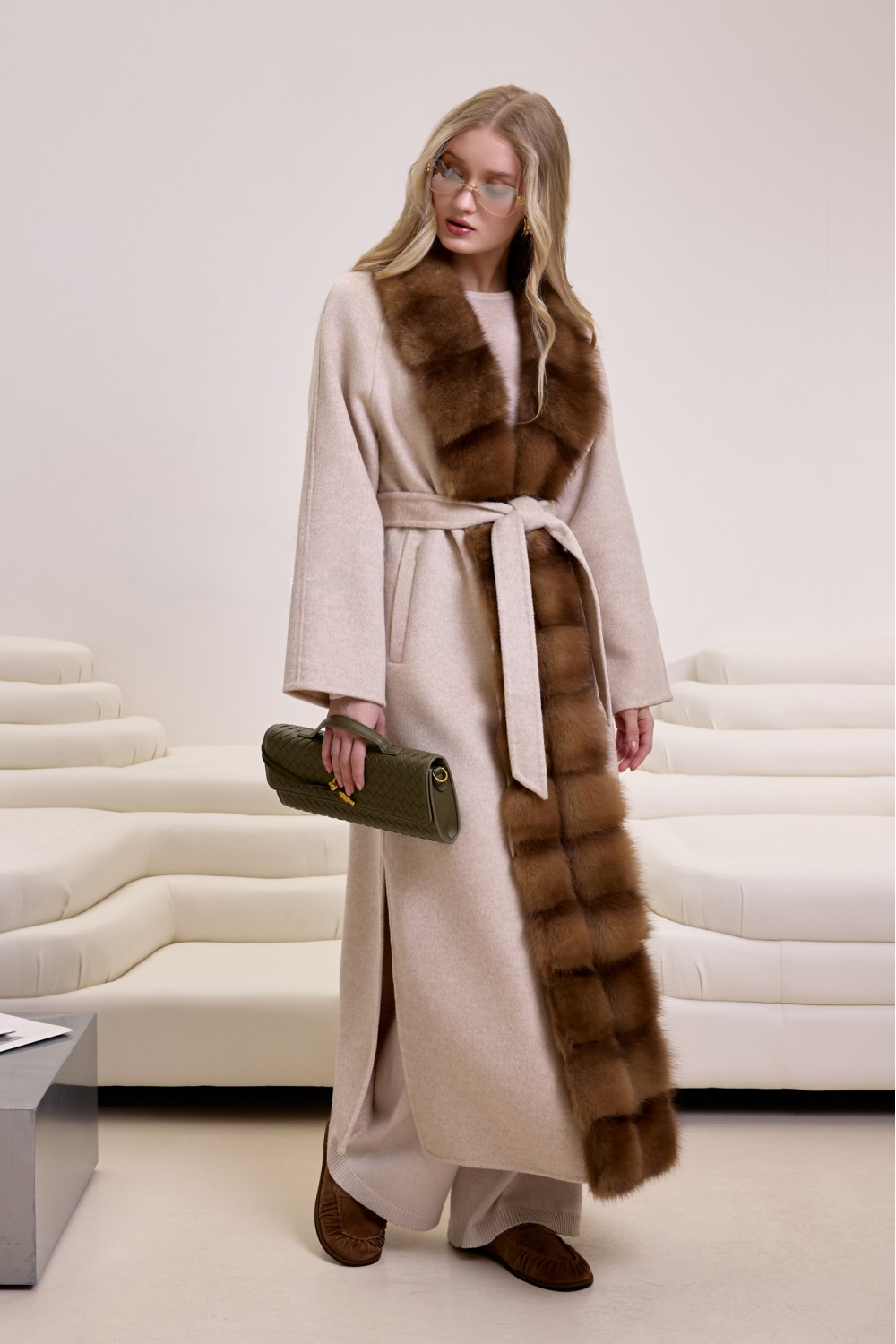 Woman wearing a luxurious beige cashmere coat with rich brown mink fur trim, styled for elegant winter fashion.