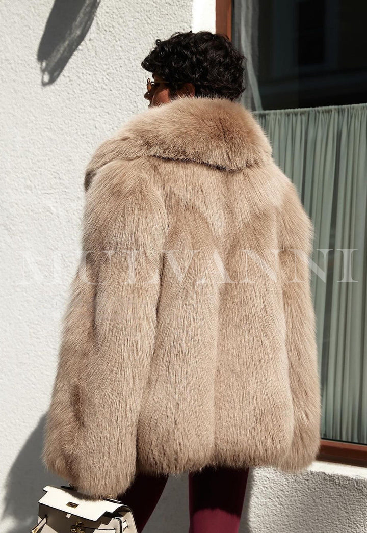 Woman wearing ROMINA Faux Fur Coat in chic taupe, showcasing luxurious oversized silhouette and rich texture resembling genuine fur.