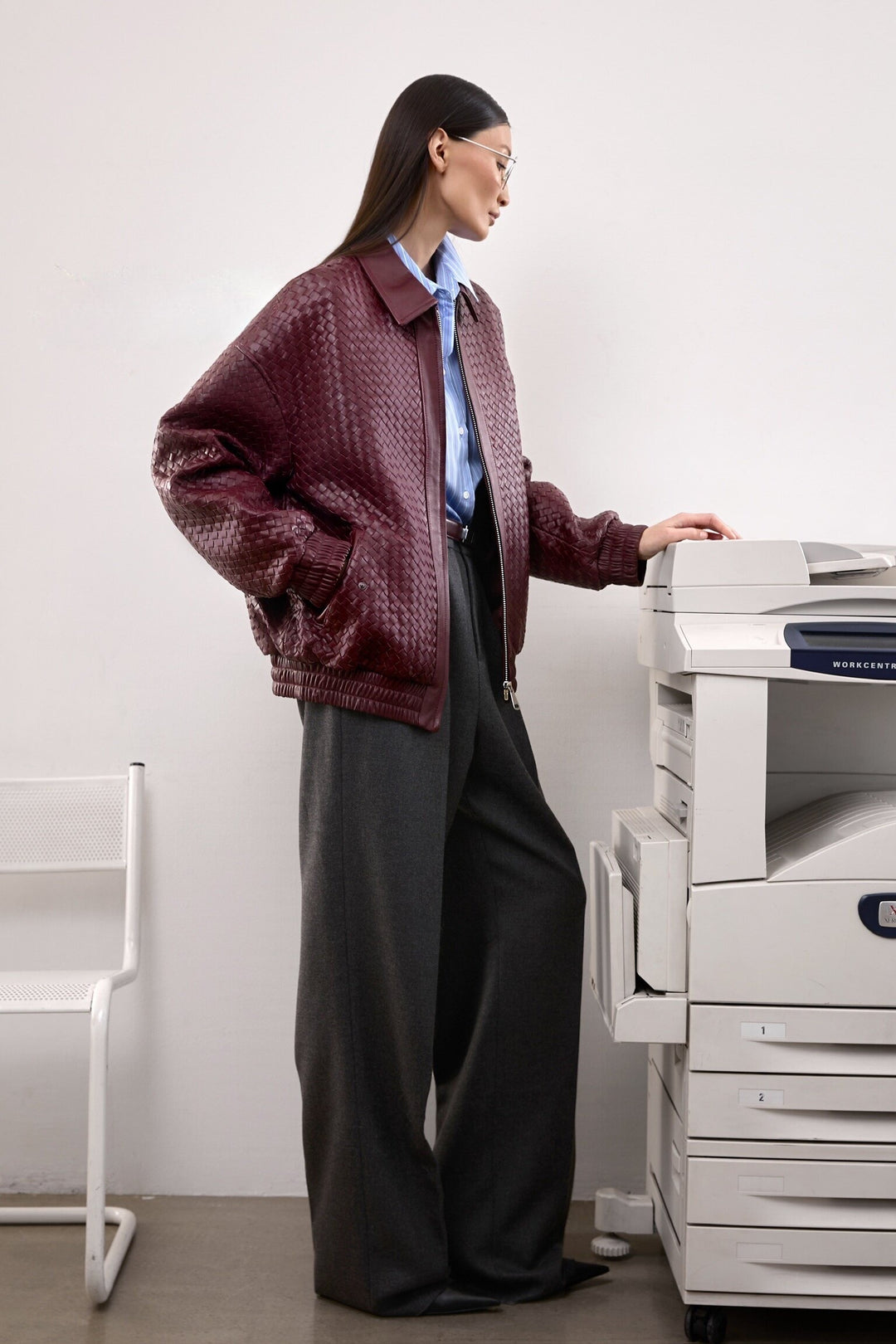 A woman wearing a rich burgundy bomber jacket with a modern cut and roomy fit, ideal for layering with ease and elegance.
