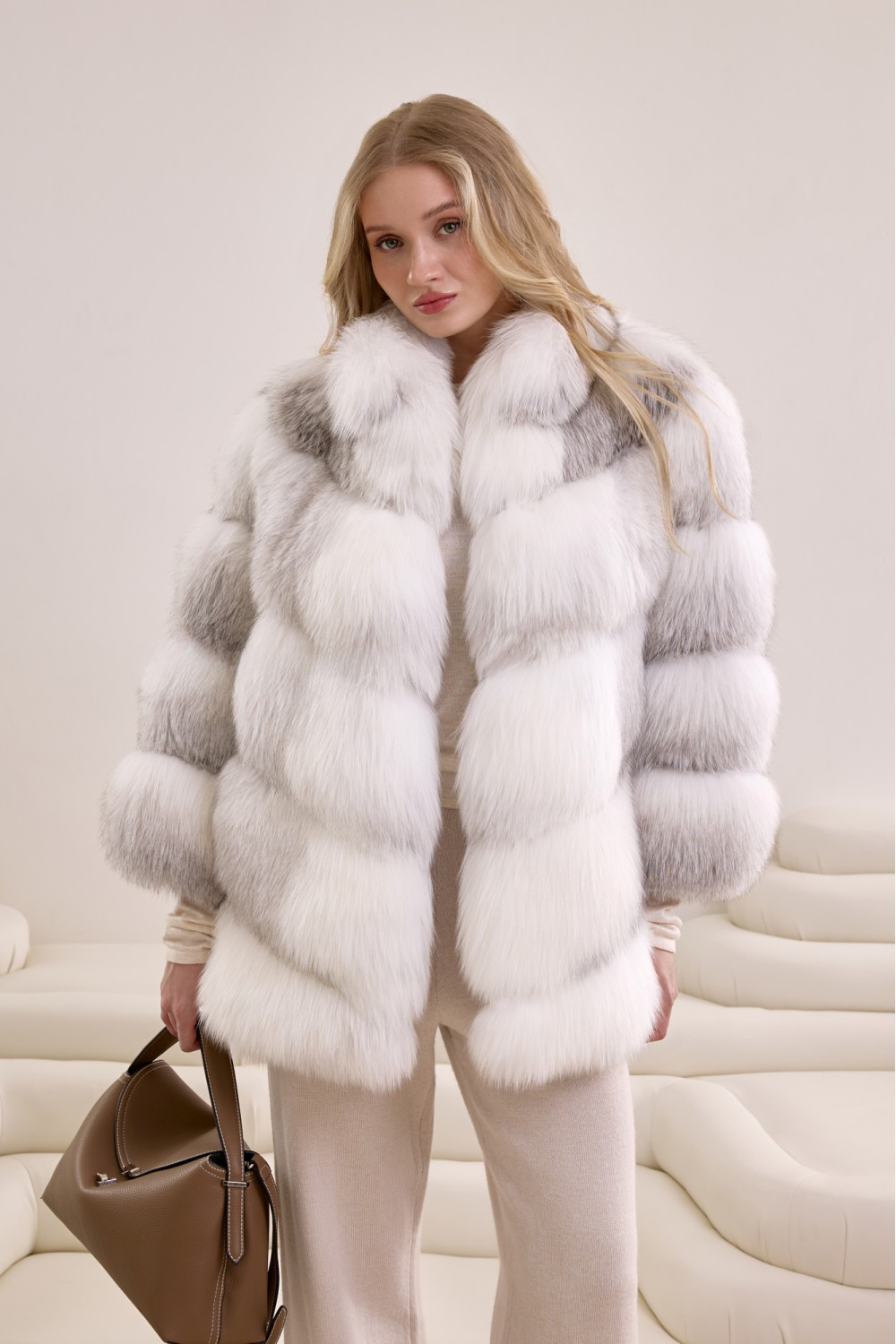 Woman wearing a voluminous Arctic Crossed fox fur coat, showcasing luxurious natural gradient hues and timeless elegance.