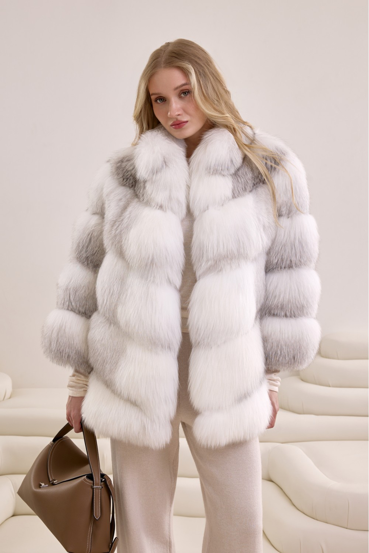 Woman wearing a voluminous Arctic Crossed fox fur coat, showcasing luxurious natural gradient hues and timeless elegance.