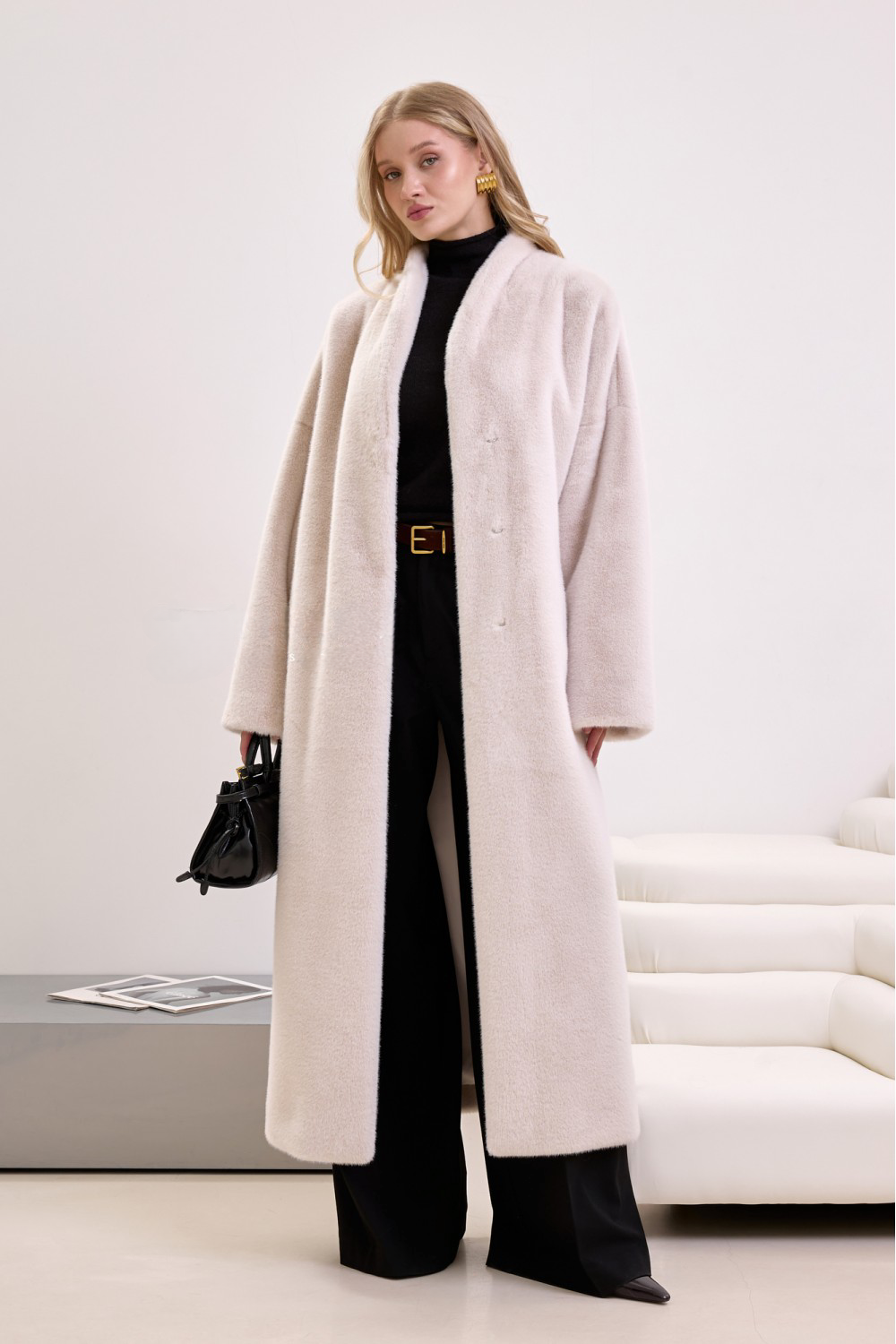 Soft beige faux fur coat with waist tie, styled for modern elegance and cruelty-free fashion.