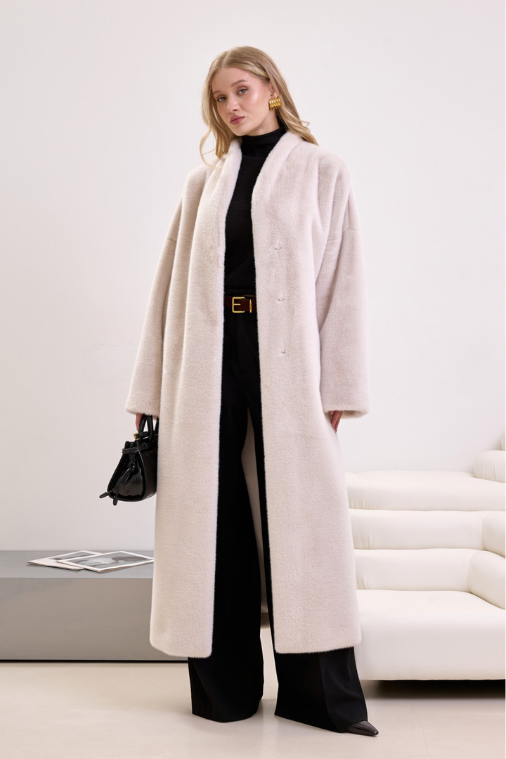 Soft beige faux fur coat with waist tie, styled for modern elegance and cruelty-free fashion.
