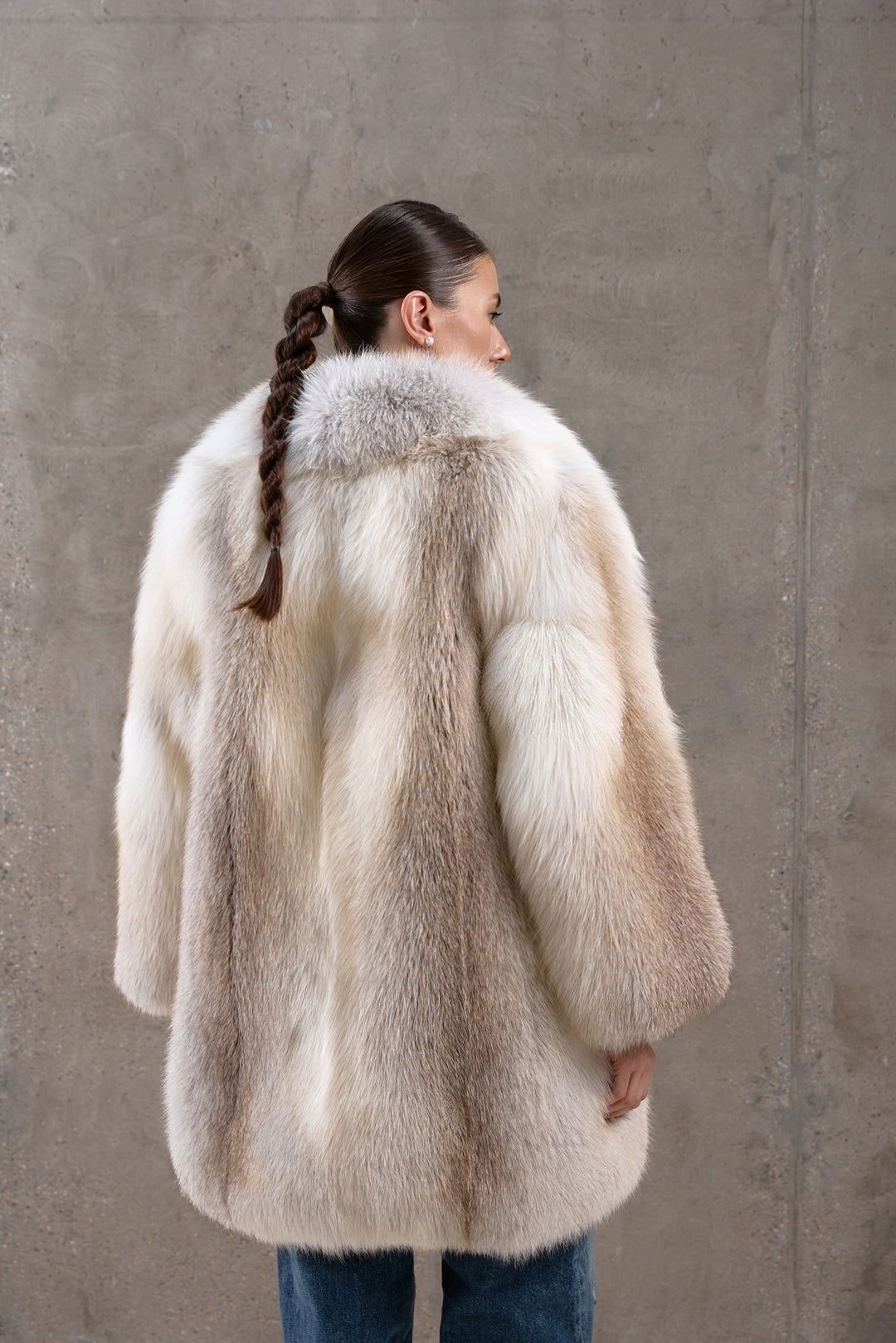 A woman wearing a richly textured fox fur coat in golden tones, designed for both timeless elegance and superior cold-weather protection.