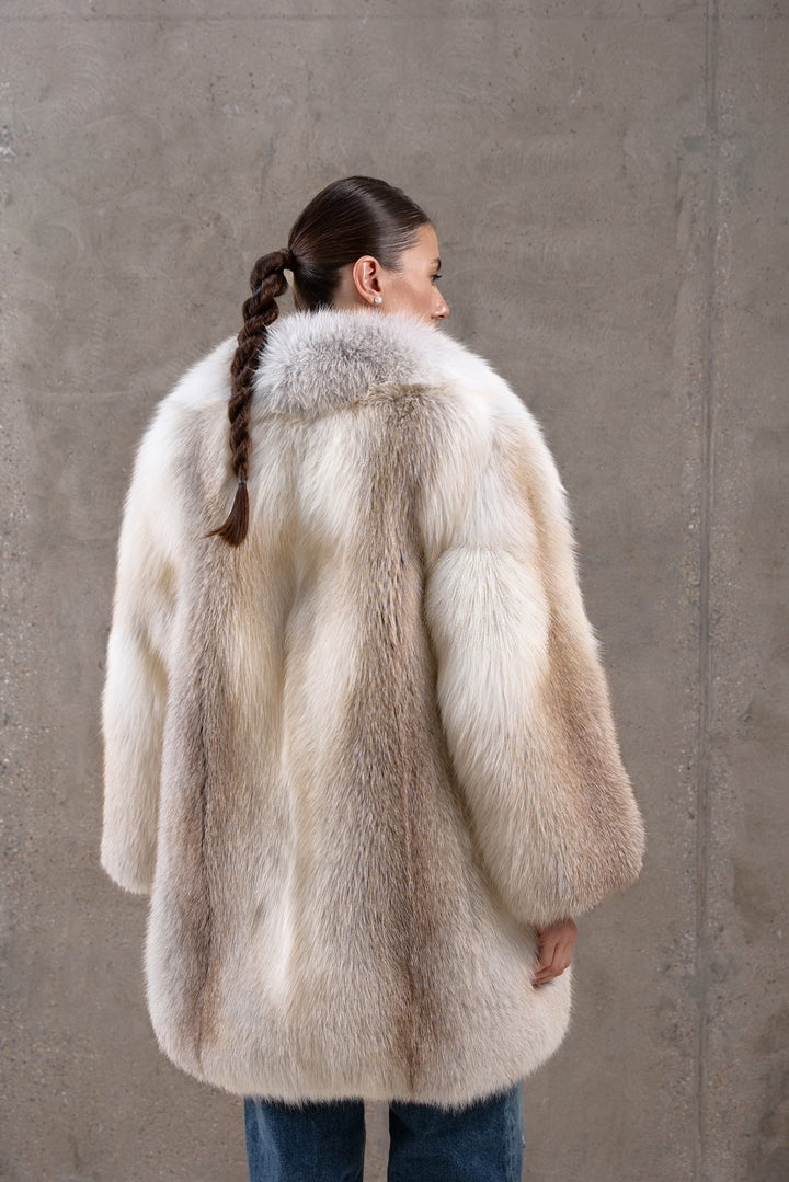 A woman wearing a richly textured fox fur coat in golden tones, designed for both timeless elegance and superior cold-weather protection.