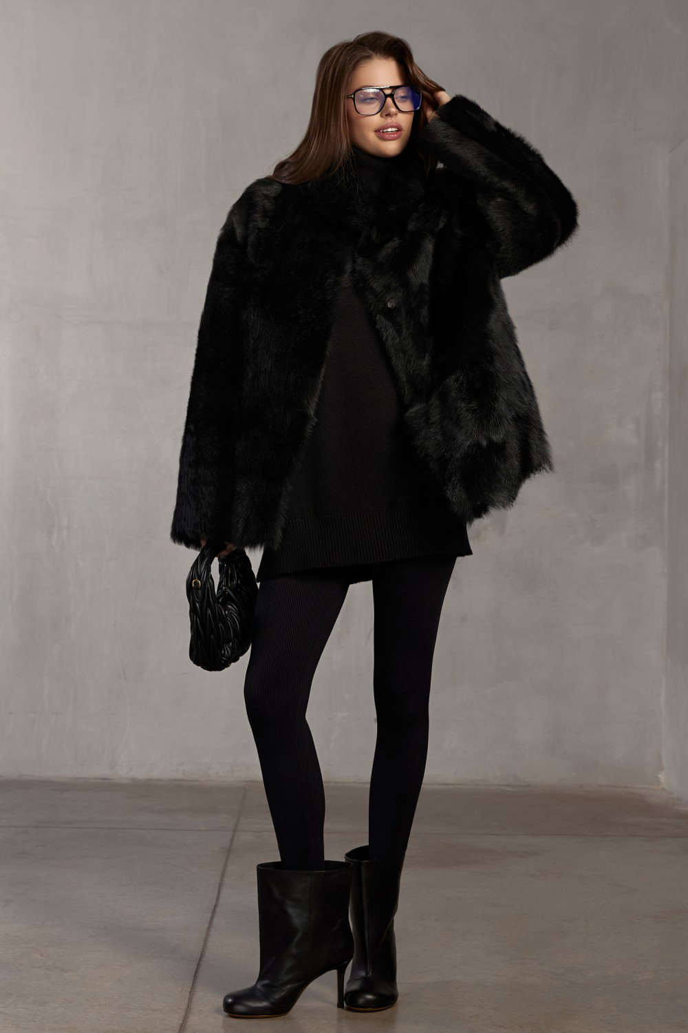 Luxurious genuine black shearling coat styled for refined cold-weather fashion.