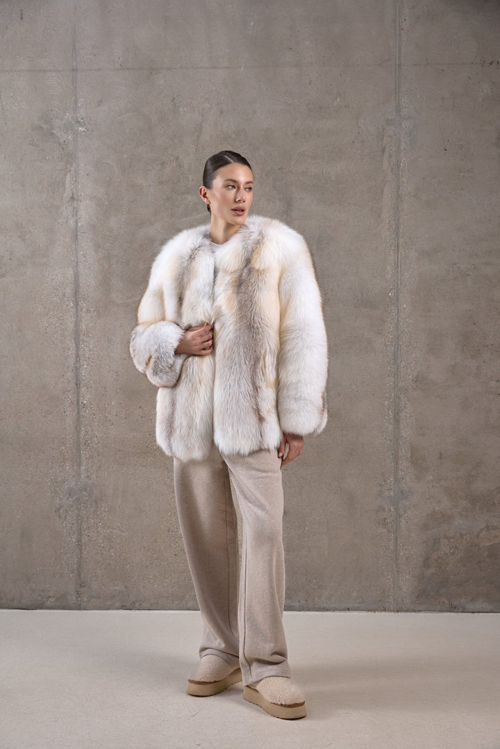 A woman wearing an oversized golden fox fur coat makes a luxurious cold-weather statement, designed for both high fashion and extreme insulation.