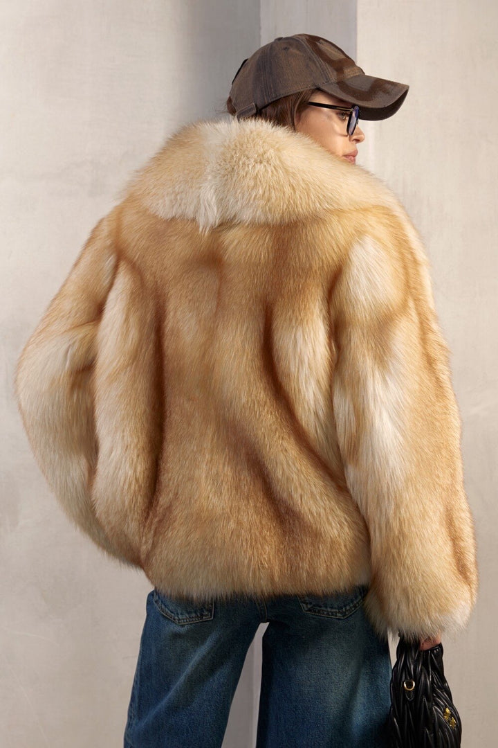 A woman dressed in a striking full pelt gold fox fur coat, exuding luxury, comfort, and sophistication in every detail.