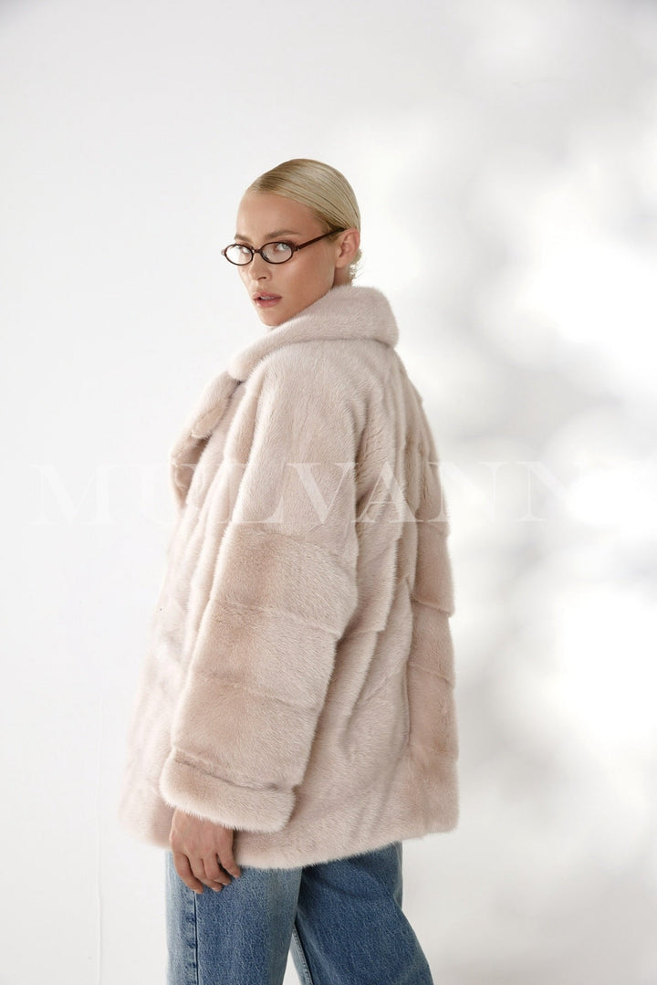 A woman styled in this timeless mink coat, featuring pure mink fur and a high-quality satin lining, epitomizing chic elegance and cozy warmth.