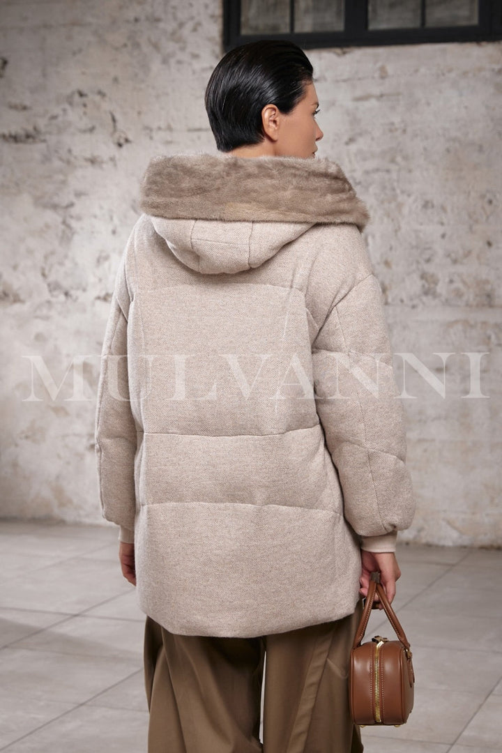 Woman models a refined down puffer with mink fur hood, capturing the balance between warmth, luxury, and modern practicality.