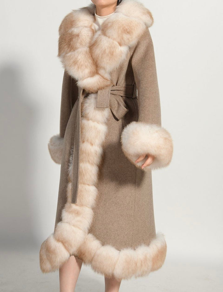 A woman wearing a wool alcantara beige coat with luxurious fox fur. 