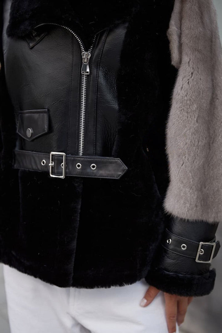 Close up of a leather jacket with grey mink sleeves. 