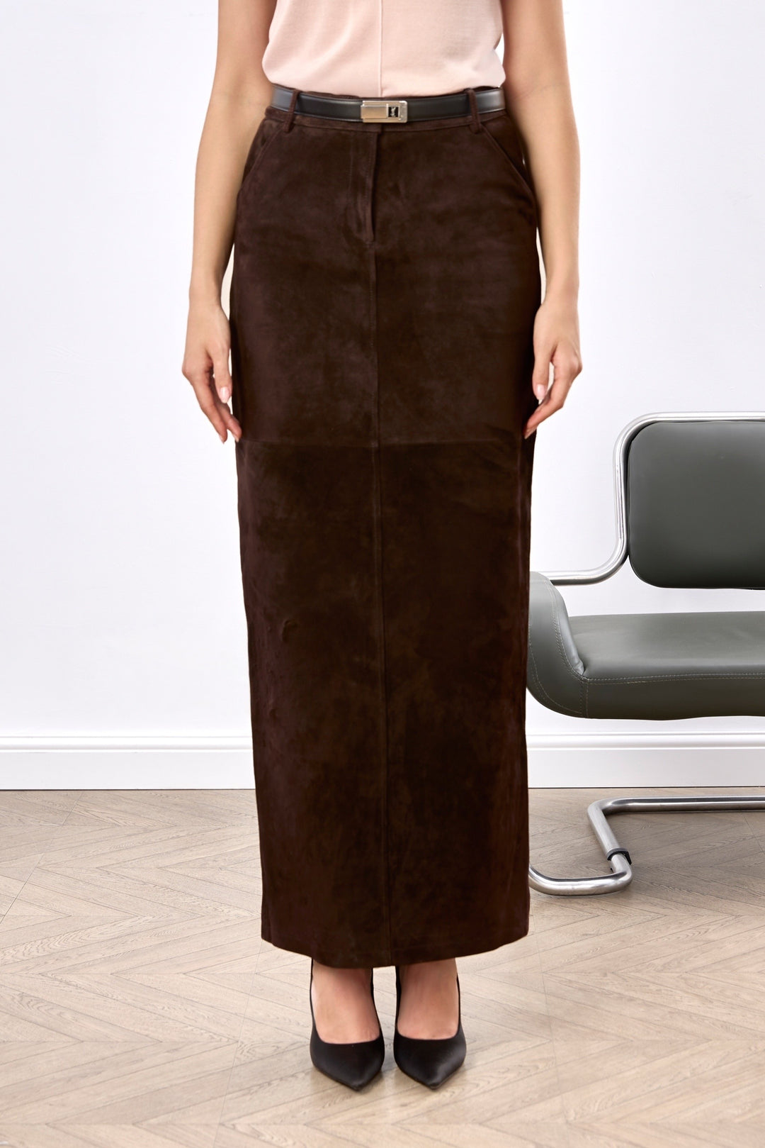 A woman wearing a luxurious brown suede pencil skirt with a high waist and sleek silhouette, exuding effortless elegance and timeless style.