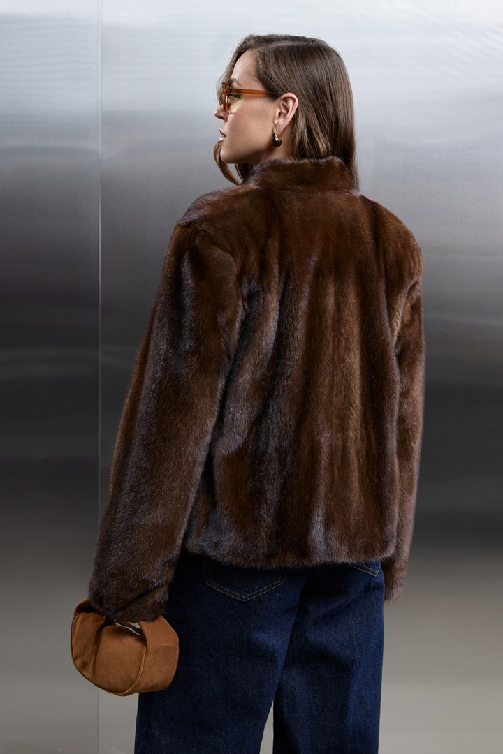 Back view of a woman in a short brown mink fur coat, showcasing elegance and luxury with a stylish ensemble.