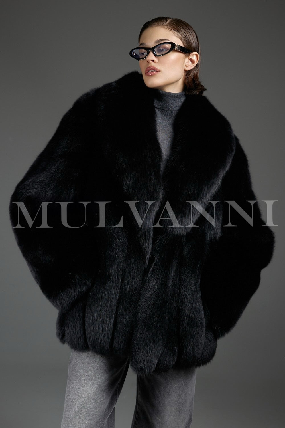 Woman wears an oversized genuine fox fur coat with a radiant sheen, exuding luxury and warmth while moving gracefully in the soft, voluminous silhouette.