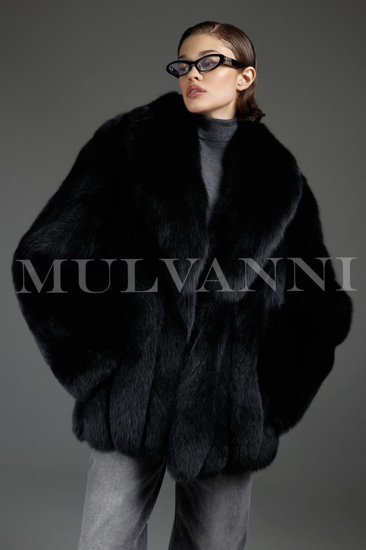 Woman wears an oversized genuine fox fur coat with a radiant sheen, exuding luxury and warmth while moving gracefully in the soft, voluminous silhouette.