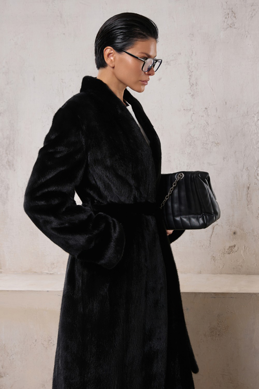Elegant woman in a long black mink coat, showcasing luxury and versatility for formal or sporty outfits.