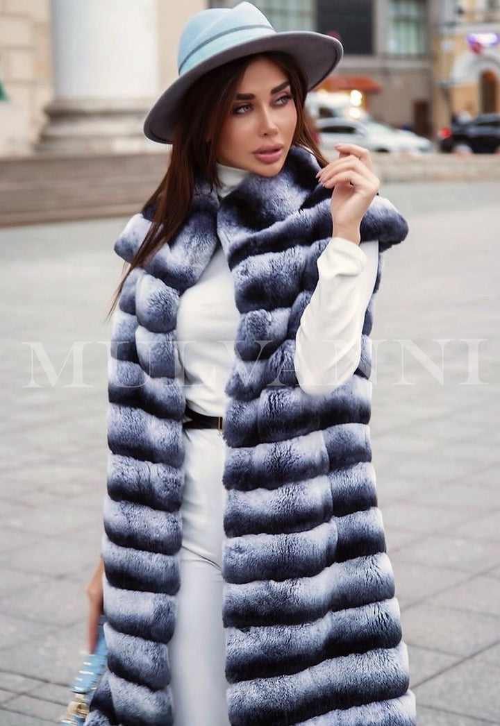  A woman dressed in a chic Rex fur midi vest, highlighting its soft texture and refined style. The vest's versatile design makes it an ideal statement piece for various occasions.