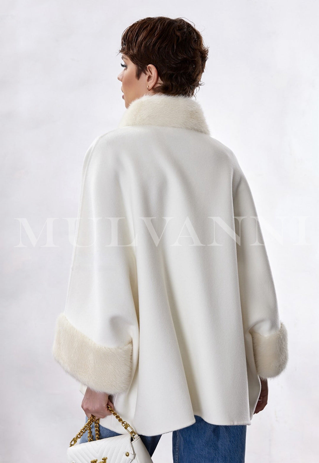 Woman dressed in a luxurious double-face cashmere coat with a structured funnel collar adorned with plush genuine mink fur, styled for elegant formal wear.