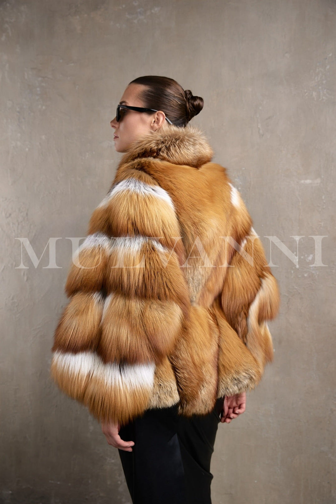 A woman wears a high-fashion red fox fur coat designed for extreme winter weather, with thick, luxurious fur, an enveloping silhouette, and a waist-cinching belt that balances comfort and couture style.