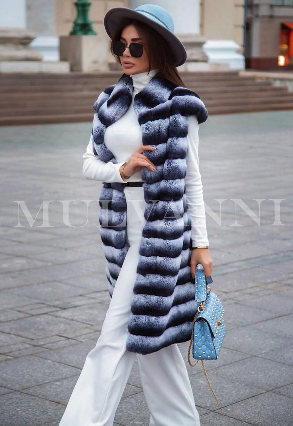 A fashionable woman in a Rex fur midi vest, showcasing its plush fur and sophisticated design. The vest adds a layer of luxury to her ensemble, perfect for cold-weather outings.
