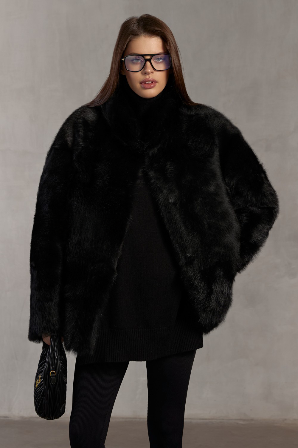 Woman wearing black Tuscan shearling coat, showcasing premium winter elegance.