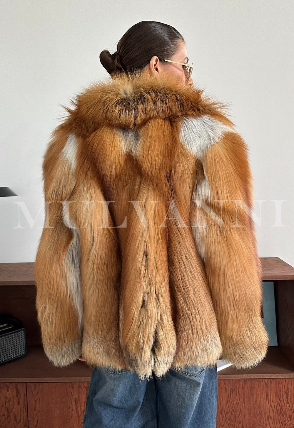Woman dressed in an elegant red fox fur coat with soft, plush fur and striking natural colors, perfect for enduring extreme cold weather.