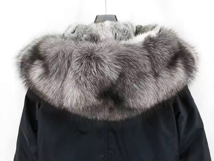 Close-up of the fox fur hood trim on a black technical parka, displaying soft, voluminous fur and precision stitching for luxurious insulation.
