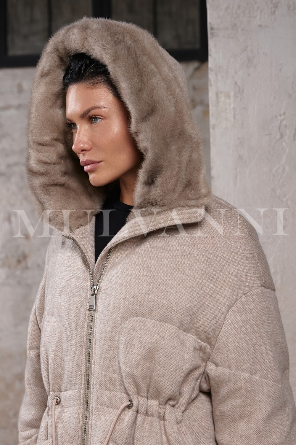 A stylish winter look as a woman layers the elegant double-face wool and down jacket, with the hood framing her face in soft mink.