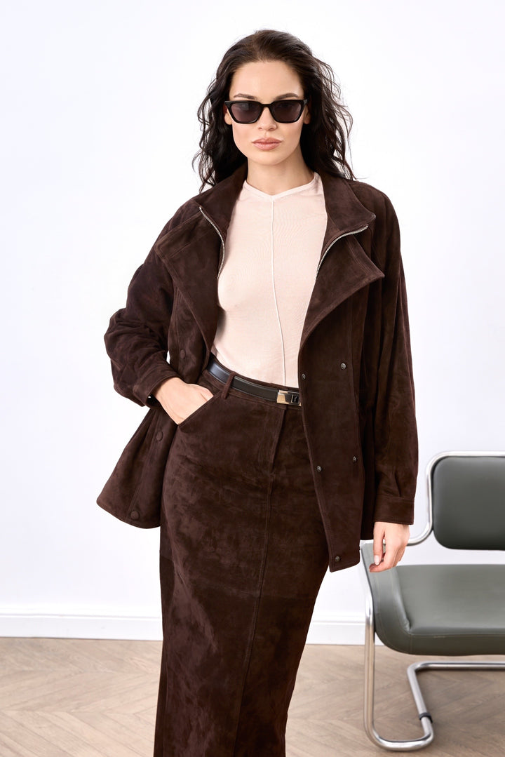 A woman models a sophisticated brown suede pencil skirt with a figure-flattering fit and high waist, offering a polished and elegant look and a suede matching jacket. 