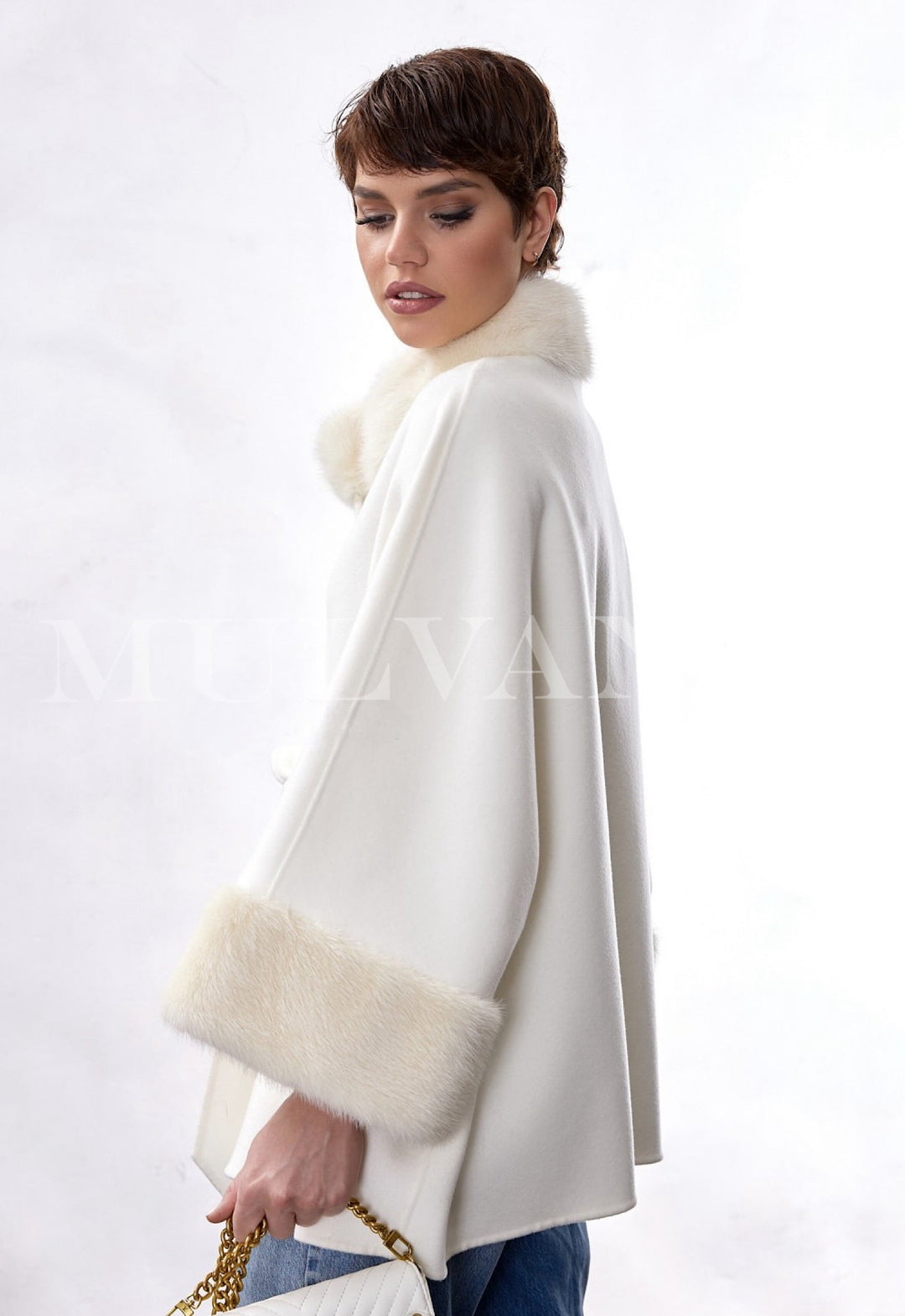 Model wears a timeless double-face cashmere coat, highlighted by a structured funnel neckline and soft genuine mink fur trim, pairing flawlessly with formal outfits.