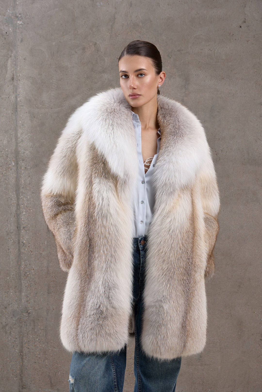 A woman wears a luxurious full pelt Gold Crossed Fox Fur Coat with rich golden hues and a voluminous silhouette, perfect for arctic temperatures.