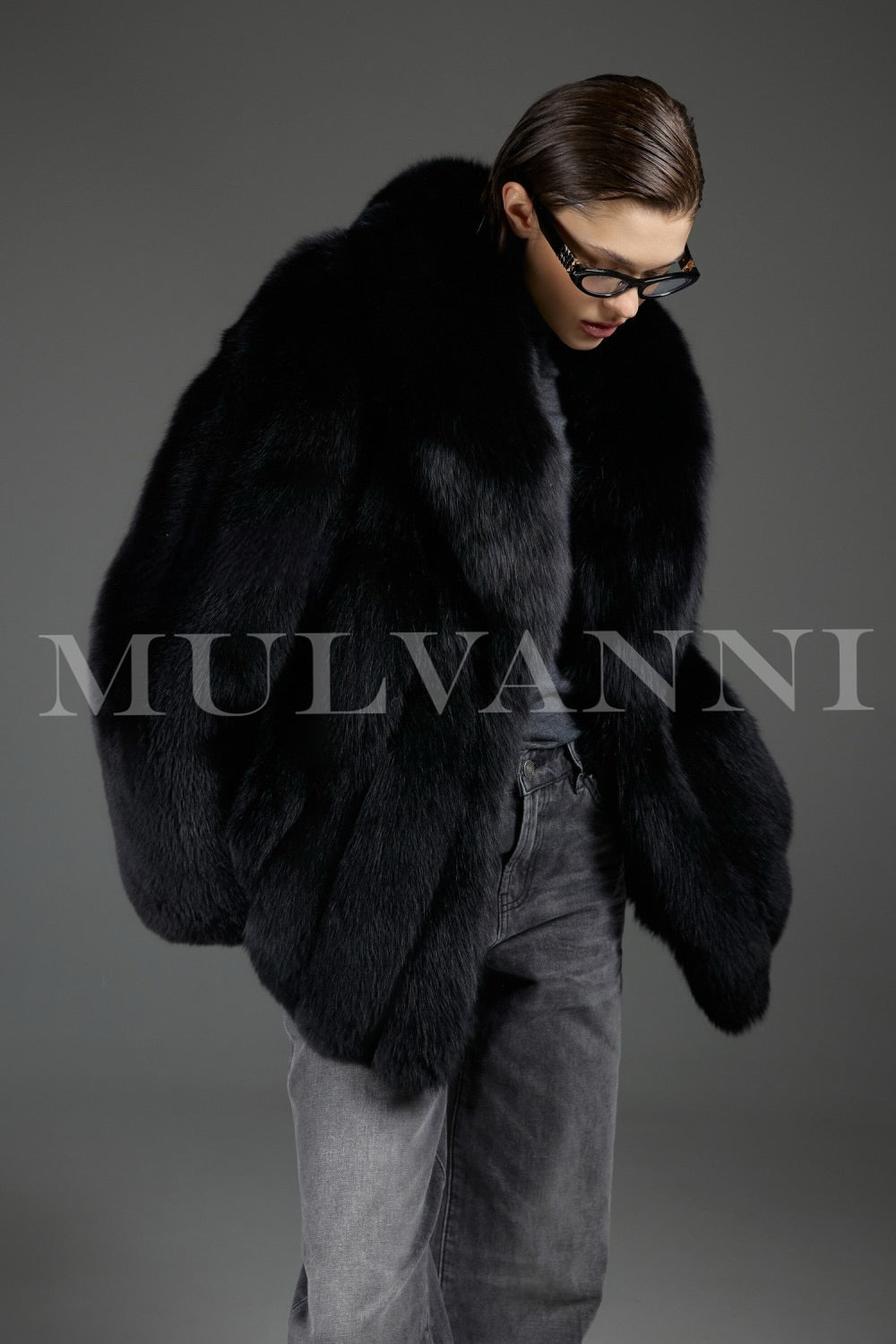 Dressed in a sumptuous fox fur coat, a woman displays elegant sophistication, the natural luster of the plush fur creating a regal winter look.