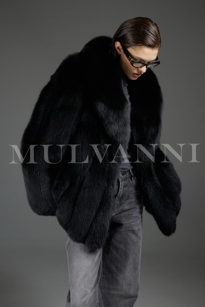 Dressed in a sumptuous fox fur coat, a woman displays elegant sophistication, the natural luster of the plush fur creating a regal winter look.