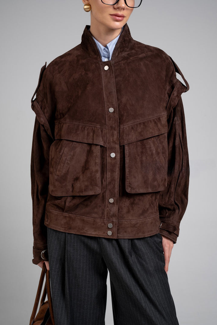 Wearing this dark brown suede jacket, the model highlights its timeless style and soft, supple texture.