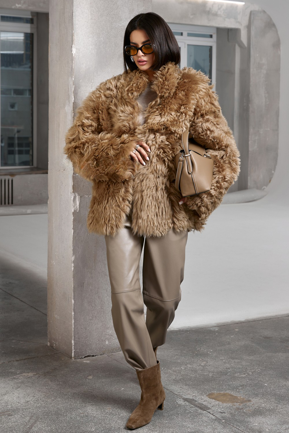 Stylish woman models a premium shearling coat in a refined ecru tone, blending warmth with timeless sophistication.