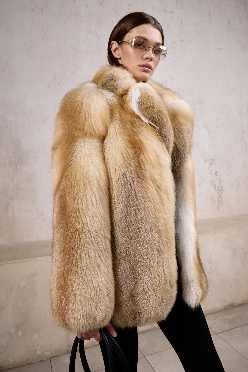 A woman wearing a lavish gold fox fur coat crafted from the highest quality full pelts, styled with sunglasses, exuding winter opulence and elite protection against harsh temperatures.