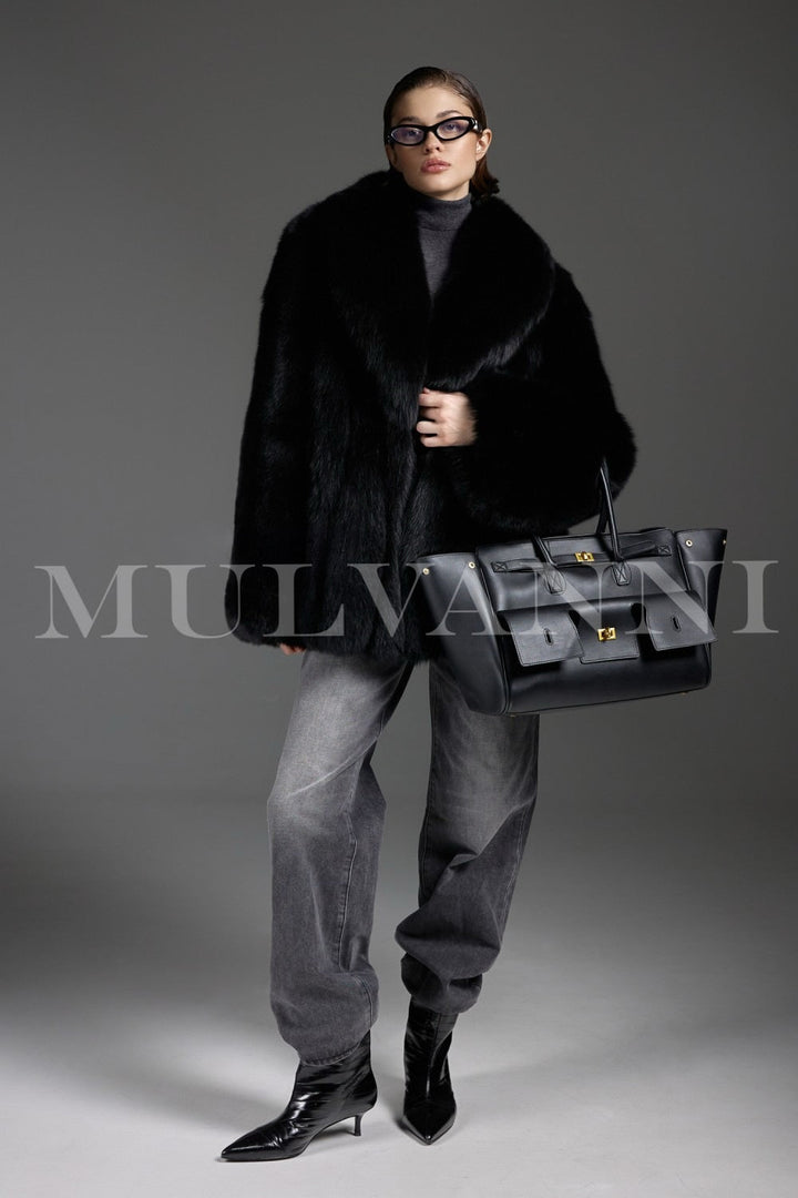 Dressed in a sumptuous fox fur coat, a woman displays elegant sophistication, the natural luster of the plush fur creating a regal winter look.