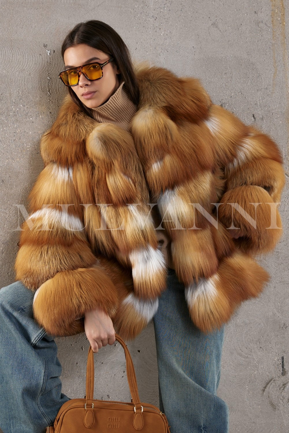 Model wears a fiery red fox fur coat over classic jeans, showcasing a refined yet relaxed cold-weather look.