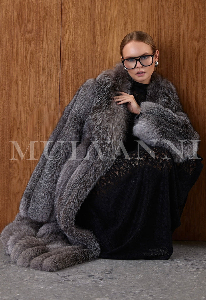 Woman draped in a glamorous long fox fur coat, the luxurious fur cascading with natural depth and shine, styled with understated accessories for refined sophistication.
