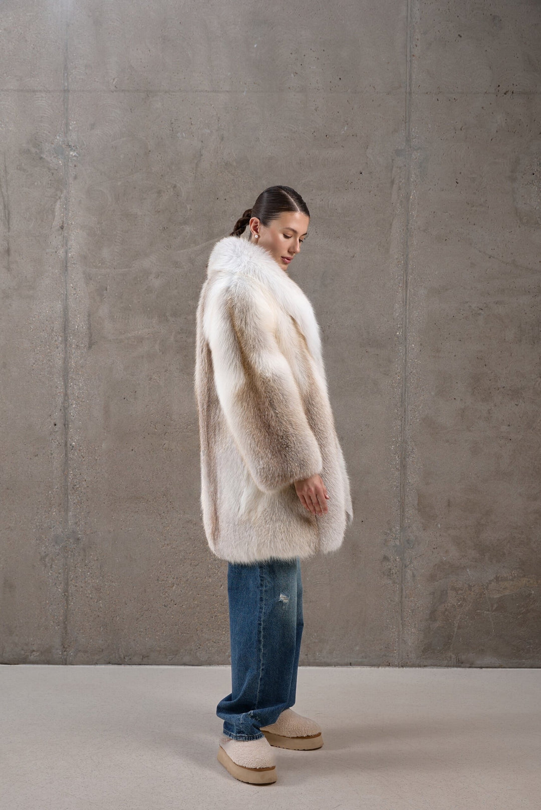 A woman showcases a full pelt Gold Crossed Fox Fur Coat, exuding sophistication and bold winter style, crafted for sub-zero conditions.