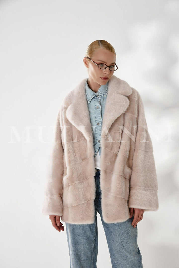 Chic and elegant, a woman dons this genuine mink coat, expertly crafted in Italy for a glamorous, warm statement piece.